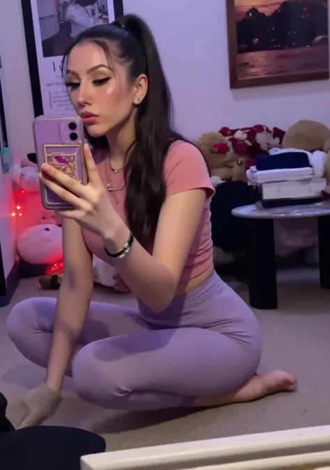 A beautiful woman wearing light purple leggings and a pink tight blouse, butt mirror selfie