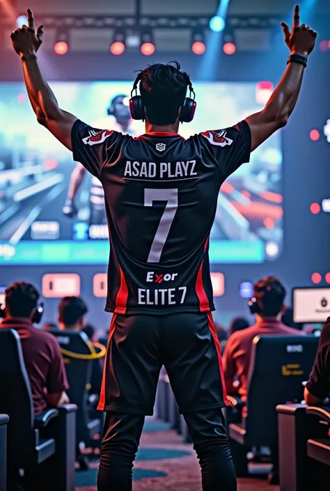 A ESPORTS PUBG PLAYER STANDING WITH WINNING POSE LOOKING NOT TO THE CAMERA WITH SHIRT NAME  ASAD PLAYZ; elite 7