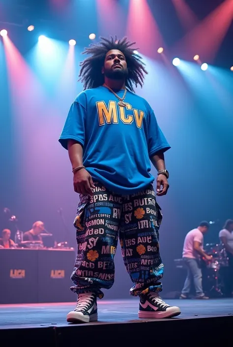 One guy standing in a big stage to rap his high 6 feet fat guy 23 age wearing blue leanth T-shirt printed MCV bagi pant in that tshirt is main its printed MCV IN A T SHIRT MCV is that guy name its be in that T-shirt 10 inch hair 