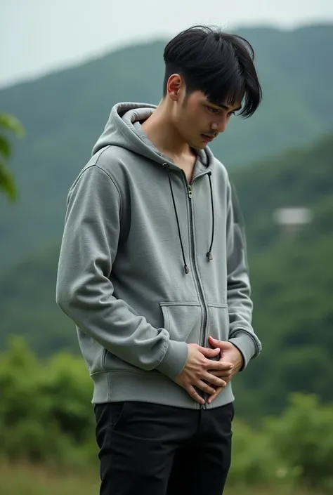 Real human photo A 23 years old man,  short  staruggt  black hair, handsome, white skin, wearing plain grey  zipped up hoodie, black  pant, barefoot, standingg  with Both hands were resting on the stomach, one on top of the other, head bowed in deep focus....