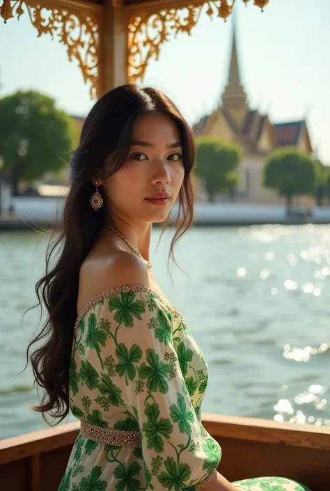 Beautiful fair-skinned Thai woman looks at the camera wearing a tropical green patterned white silk dress enjoying a boat trip on the Chao Phraya River with the glittering Grand Palace as a backdrop.