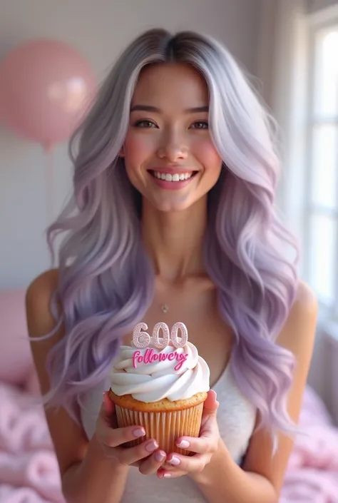 Gorgeous woman with long wavy silver grey lilac tint ombre hair holding a little cupcake that says “600 followers” she is smiling happily and looks beautiful