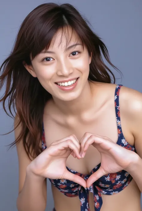 A smiling woman is posing alone wearing off-the-shoulder pajamas, making a firm big heart shape with both hands, and holding them in front of her chest, View above collarbone、The background is a monotone 、
