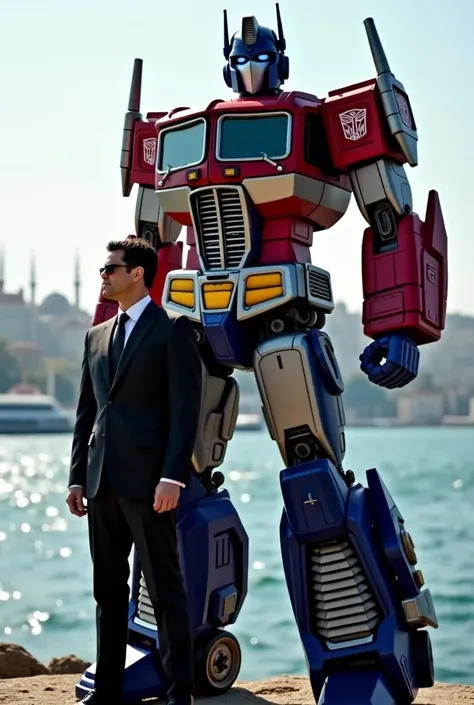 Optimus prime and next to it a 1.80-meter-tall man in a dark black suit look out towards the Bosphorus.