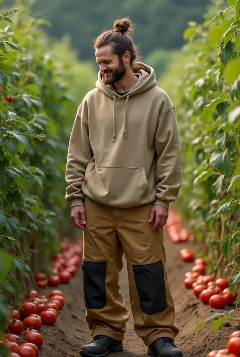 Un homme blanc de 30ans. Il a les cheveux long, bruns, attachés en bun. Il a une petite barbe fine et une moustache. Il a 2 boucles doreilles à gauche. Il porte un sweat a capuche large de couleur kaki et un pantalon de travail large couleur camel avec des...