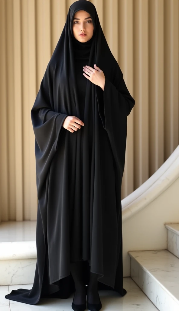 She is wearing a traditional black chadori that covers her head and body. The woman is wearing black tights and black high heels. Her hands are positioned so that one is resting on her chest and the other on top of it, her fingers lightly touching the fabr...