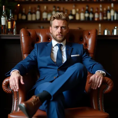 A man in a blue suit  ,   wears a white shirt and a blue tie  ,  with crossed legs and back supported on a brown leather sofa with tall wood and leather backrest looking at the camera with a determined face and safely with bar and blonde hair, una persona ...