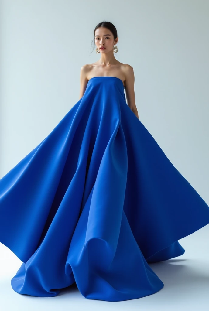 A model wearing a big triangular blue dress