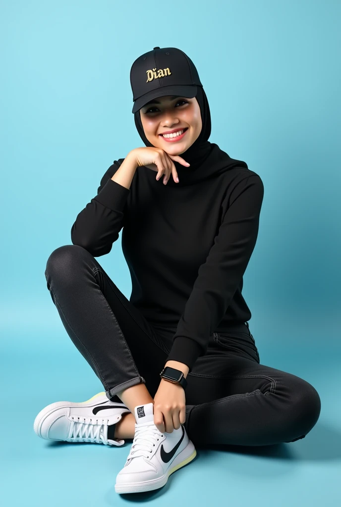  Photo Dian ladydian is sitting playfully against a light blue background .  She wears a modern and neat hijab wears a black base ball hat with the name  "DIAN"  written in metallic gold .  Dian looks current ,  wearing a black t-shirt , black jeans , Appl...