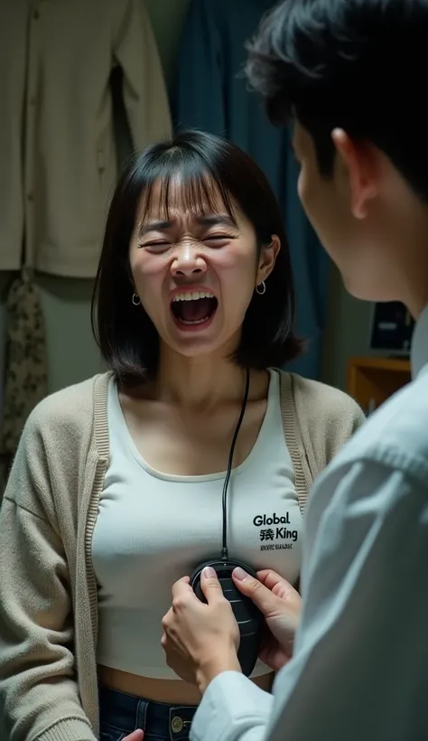 A Japanese woman makes a crying face when her chest is kneaded by a man with an electric machine from the top of a white Vans logo t-shirtGLOBAL WORKのカーディガンを羽織る