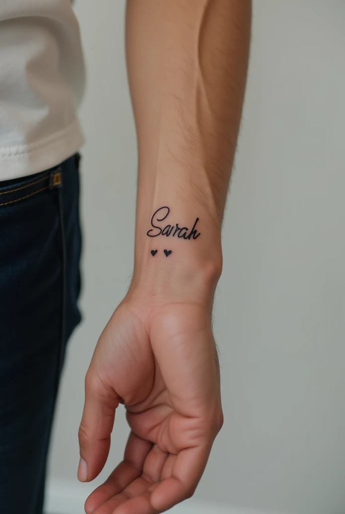 a very realistic photo of the forearm of a young man with “Sarah” tattooed in cursive letter with a small heart 