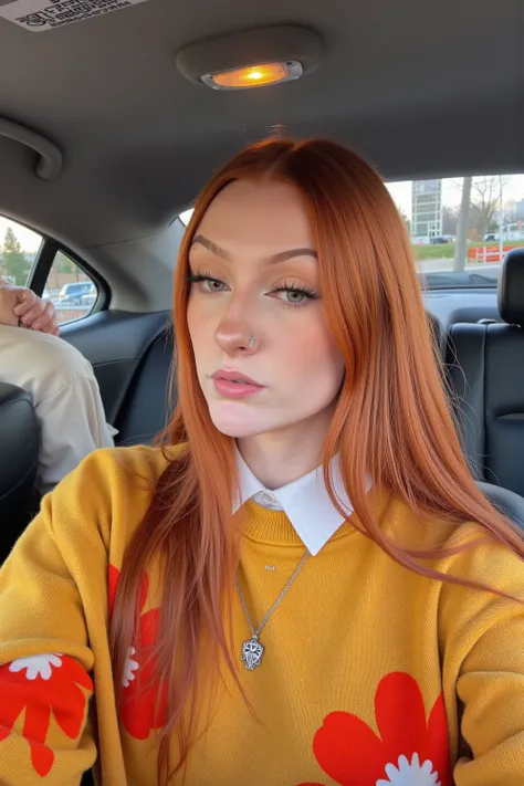 emmaleiah. This photograph captures a young woman sitting in the backseat of a car, taking a selfie. She has long, straight, vibrant red hair that cascades down her back and shoulders, contrasting with her fair skin and striking facial features. She has a ...