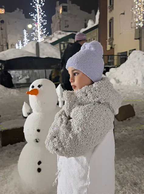 baby girl with a snowman looking at us winter comfort city photo photography studio photo high quality realism