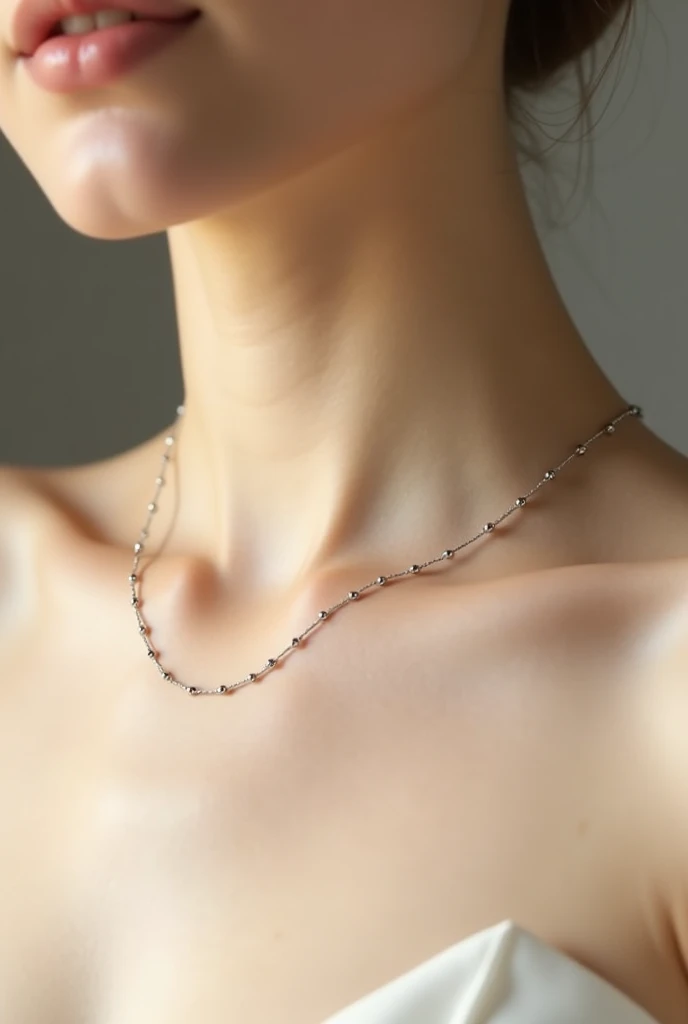 A small, thin necklace on a white chest