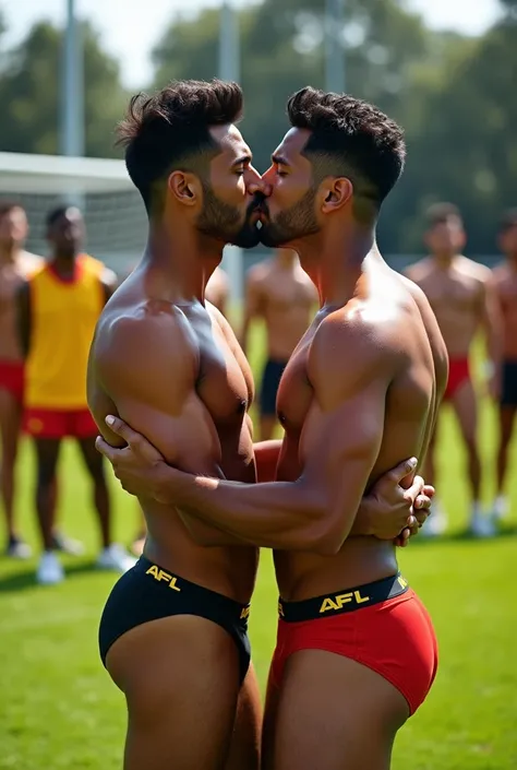 Two gay Indian men that are toned muscular wearing thong underwear which are afl football branded. They are kissing at football training with teammates watching. They are both 37 years old. Make photo very realistic. 