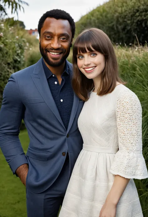 British Caucasian actress Felicity Jones and Black English actor Chiwetel Ejiofor pose together for a photo. Both are smiling. Both look happy and in love with each other. Both are attired attractively but casually for a date. Felicity has lovely makeup on...