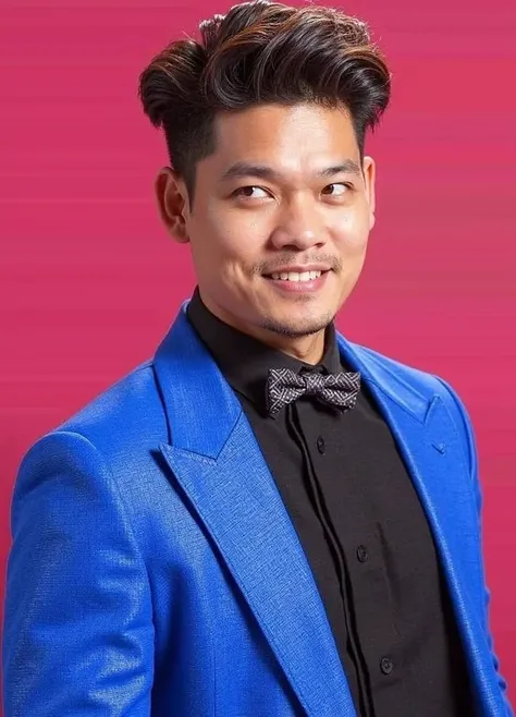 A man of Asian descent,  likely in his 20s or 30s, is depicted. He is wearing a vibrant royal blue suit jacket over a black collared shirt and a dark patterned bow tie. He has short, styled dark brown hair and a pleasant, smiling expression. His facial fea...