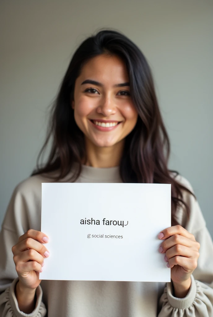 Can I get an image with a  holding a paper with a text "AISHA FAROUQ GRC SOCIAL SCIENCES"