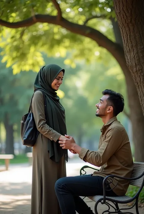 A man with distinctive Indonesian facial features is sitting affectionately holding the hand of a hijab-wearing woman in a city park. The atmosphere of the park is filled with green trees , park bench , and walkways .  They are standing near a huge tree , ...