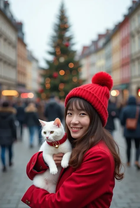 Asian woman went abroad to celebrate Christmas, bringing along her white cat wearing a red collar with a bell. She wore a red coat and a new red pom-pom hat. In the picture, there is a Christmas tree in the center of the town, surrounded by many people wal...