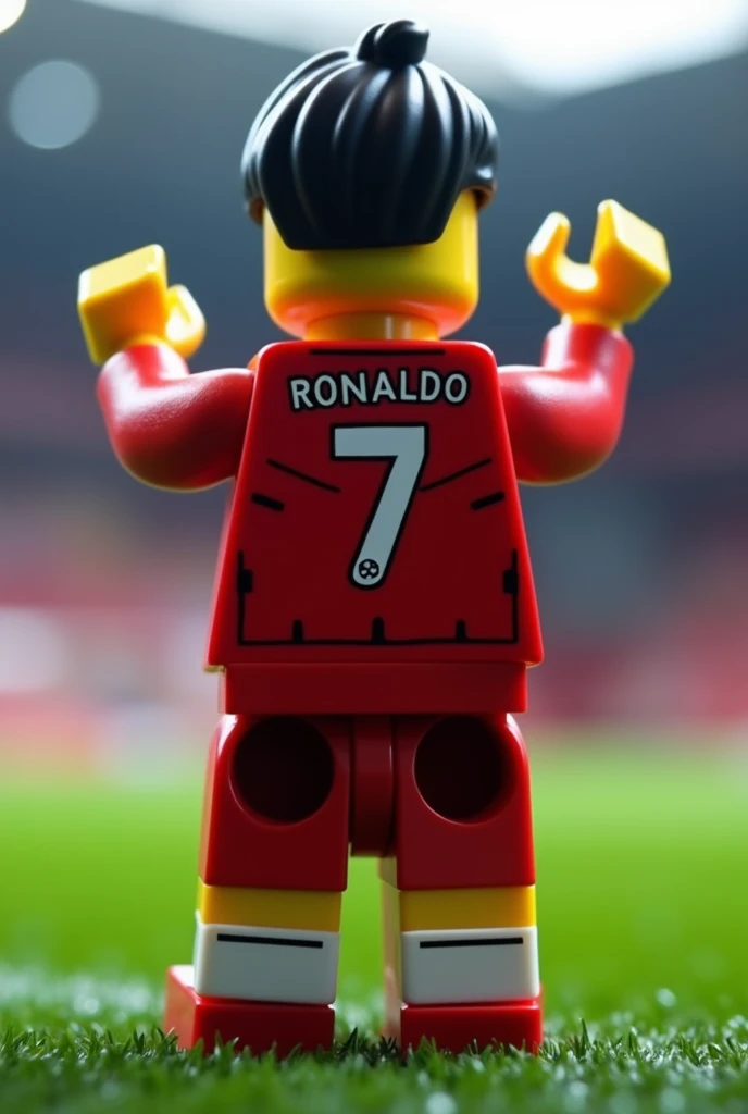 

"A LEGO version of Cristiano Ronaldo, with his number 7 Manchester United jersey, performing the Siiuu celebration with his back turned. The scene is set on a football field, with the text Ronaldo 7 displayed on the back of his jersey. The image is ultra...