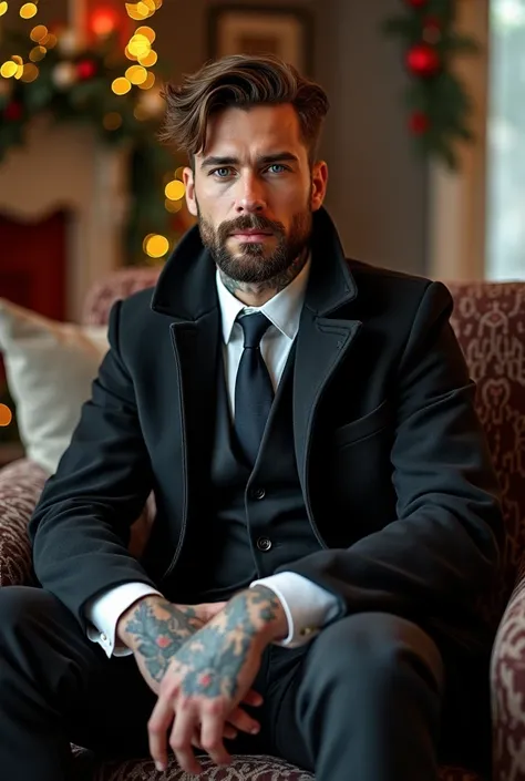 Blue-eyed man brown hair tattoos trimmed beard clothing dress coat and tie and a long black coat sitting on a couch in a decorated Christmas room 