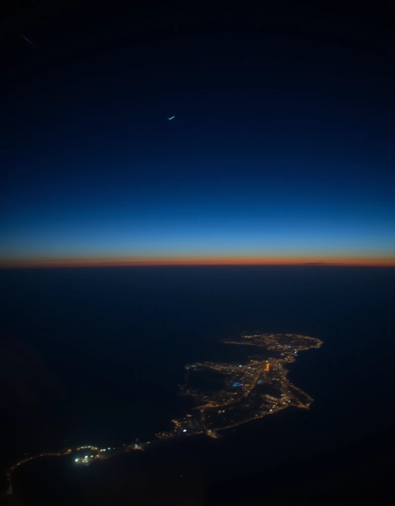 Night Flight, Citylights, romantic vibes, The sky above is dark and starry, sky below is a gradient from dark blue to blue, shooting star. F-stop 2.8, Shot with an anamorphic lens, blurry photo