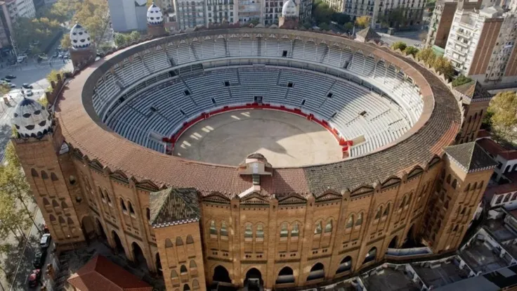 A realistic architectural transformation of the Plaza de Toros La Monumental in Barcelona into a luxurious circular hotel with a central courtyard café. The design retains the original circular structure of the bullring and is limited to three floors to ma...