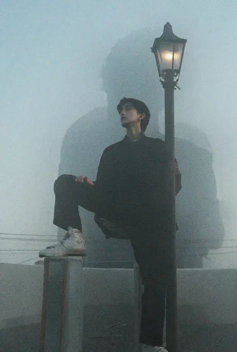 Now add a shadowy person with middle cut hairstyle ,having right leg onto the lamp post stand,and looking at the sky, with a sharp jawline and a well modern fashioned Korean style shirt and pant, make sure them to be shadowy but understable,and make him a ...