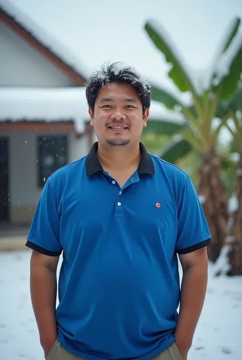 Half body photo of a 23 year old handsome slightly fat white indonesian man standing outdoors in a cool environment. He was cold, wearing a blue polo with a black collar, and standing in front of the rice fields. his hair is covered with snow, the roof of ...