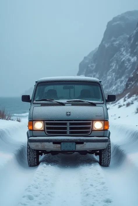  A 1995 Dodge caravan brand vehicle is waiting at the beginning of the ramp in a snowy weather.The headlights are open behind the sea is covered with cliffs leading to the sea 