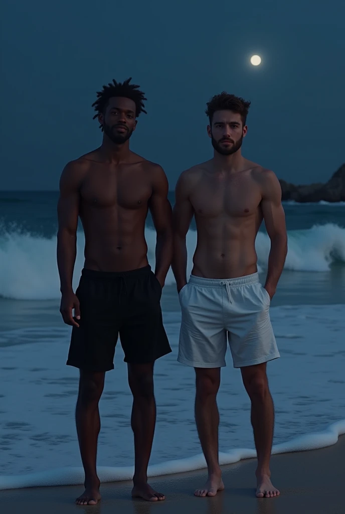 A white man in black shorts and one black man in white shorts at the beach at night