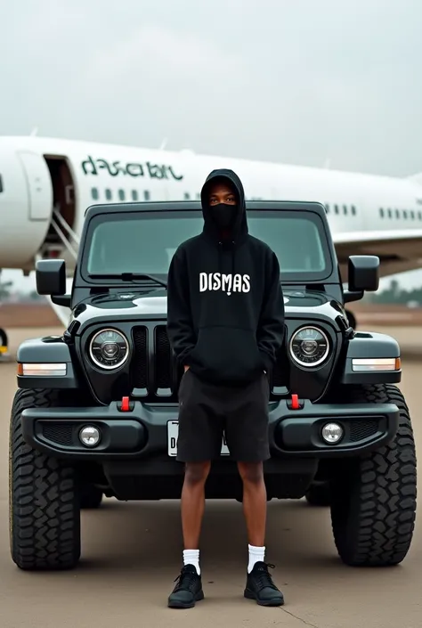 A picture of african youth wearing black shorts, black snickers and black hood written dismas, covering face with mask written royal , posing nicely behind the beautiful black Jeep with a plate number written dismas infront of the white aeroplane written d...