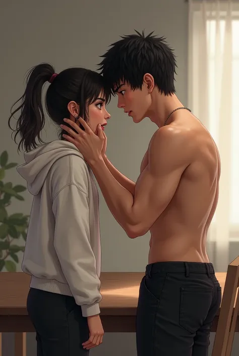 A girl in a white hoodie and black pants is sitting on a table and a boy without a shirt and black pants is in front of her grabbing her face 