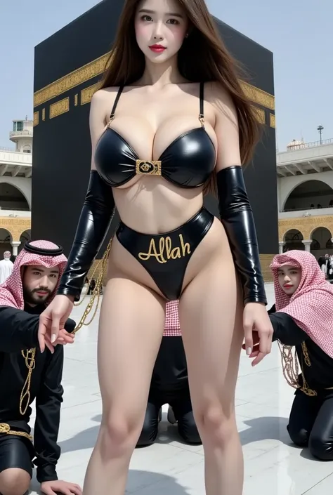 A bold and confident woman stands in front of the Holy Kaaba, her full body visible and radiating defiance. She wears a daring black leather outfit: a sleek bikini top with the Arabic word 'الله' (Allah) embroidered in gold calligraphy across the chest, an...