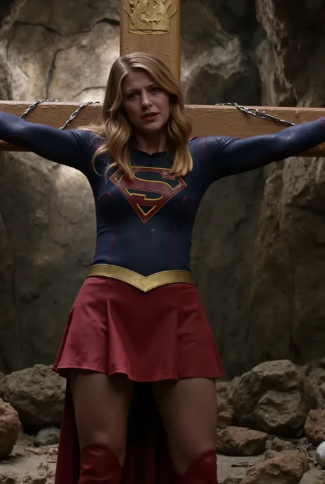 Melissa Benoist as Supergirl, the Supergirl is crucified attach the cross, her wrists are bounded to the cross by chain, she is unconscious, eyes close, She is wearing a Supergirl costume with red skirt, pantyhose and red knee height boots, her condition i...