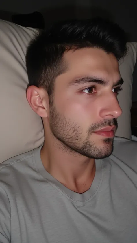 very handsome young turkish guy with muscle, dark short hair fade and goatee selfie and  he is in bed his head is on pillow and looks left he wearing a basic tshirt selfie amateur selfie