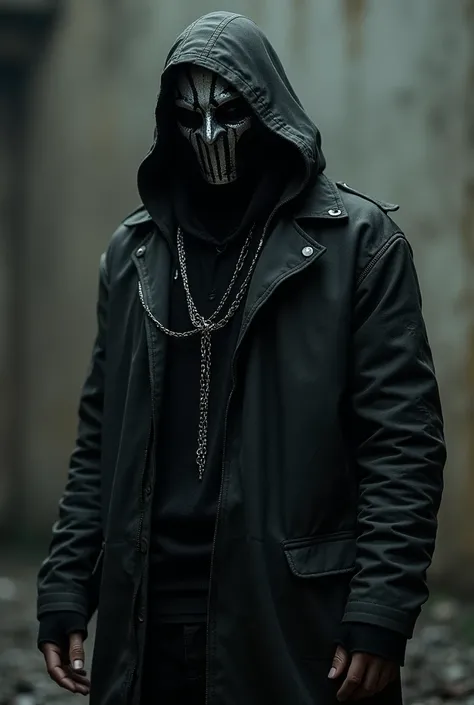 Man wearing all black, some clothing is distressed and has a mask that has silver lining all over it, with a silver chain hanging on the mask.