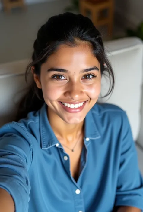 Sri lankan woman age 20, hair tied, a selfie pose, wearing blue baggy shirt, sitting on a couch posing