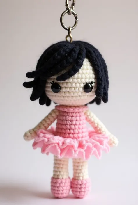 Make an amigurumi keychain for a doll with short hair, the right side in black and the left in pink with a pink tutu dress and pink shoes