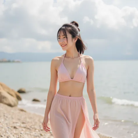 A young woman, likely in her late teens or early twenties, of Asian descent, is pictured on a beach. She is light-skinned and has shoulder-length dark hair styled in a bun.  She is wearing a halter-top, light pink, satin-like bikini top with a deep V-neckl...