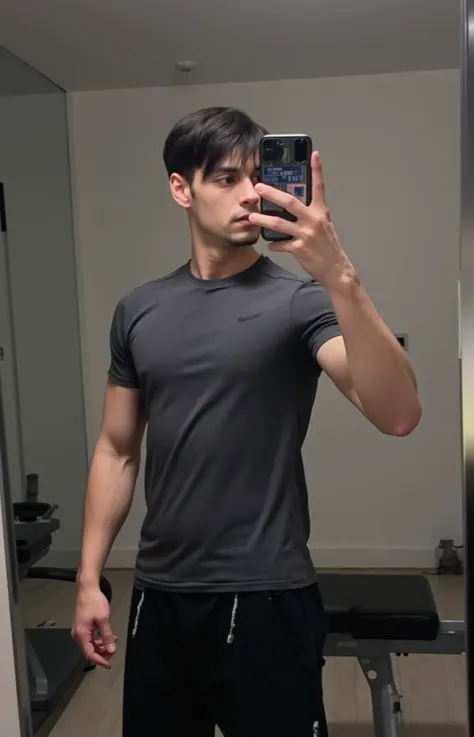 very handsome young turkish guy with muscle, dark short hair fade and goatee selfie and  he is in gym and  selfie he wearing fitness clothes  tshirt amateur photo random picture amateur picture in a wc iphone 16 pro in black