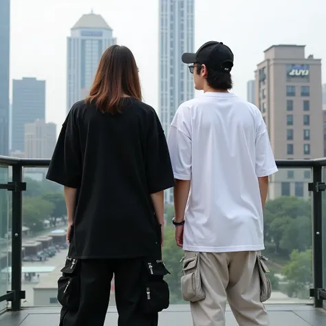  The image shows two people on their backs in an urban environment with tall buildings in the background .  The person on the left is wearing an oversized black t-shirt and black pants with pockets and straps ,  The person on the right wears an oversized w...