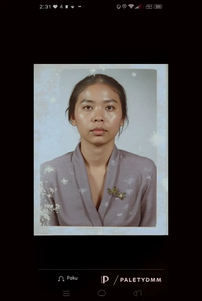 a photo of a woman wearing a blue kebaya with her hair in a neat bun