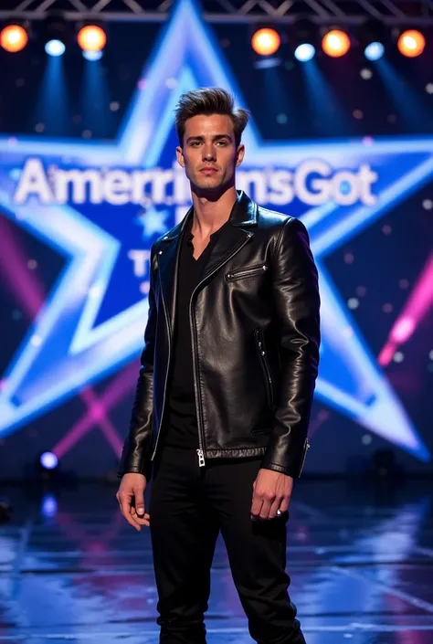 A stunning male performer stands on the America’s Got Talent stage. He has thick eyebrows and sharp, well-defined facial features, with slightly tousled, naturally styled hair. His outfit is a perfect blend of glamour and sophistication—a sleek black leath...