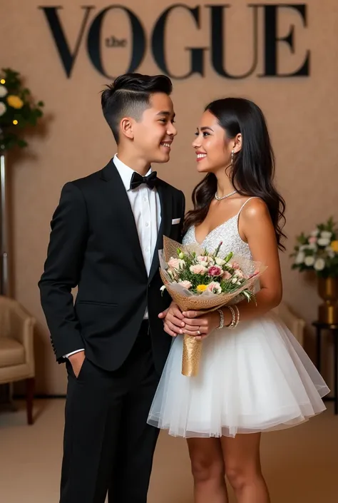  The photo shows a young couple at an event with an elegant background that includes the word “VOGUE” and luxury details,  such as a sophisticated armchair and a decorative table .
	• Clothes: The boy viste un traje negro formal con camisa blanca y corbata...