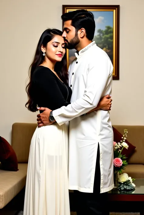 The image shows a couple in a romantic embrace in a living room. The man is on the right side of the image, wearing a white kurta and black pants, and the woman on the left is wearing a black top and a white skirt. They are standing close together, with th...