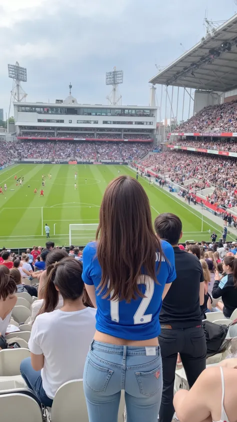 Female supporters watching a soccer game、The woman watching soccer in the spectator seat of a stadium where many people are watching the game has long brown hair、The upper body is wearing a blue soccer uniform、 The lower body in the composition seen from t...