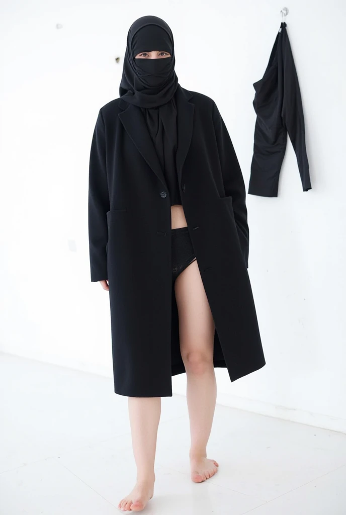 An Iranian woman is wearing a black headscarf and a short black coat that reaches up to her buttocks. She has taken off her pants and is naked, hanging them on a nail on the wall. The back view and white background are seen in full length.