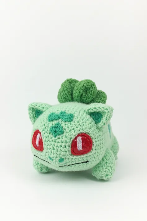 A crochet bulbasaur plushie in pastel green yarn, large red eyes with a glossy finish, kawaii aesthetic, isolated on white